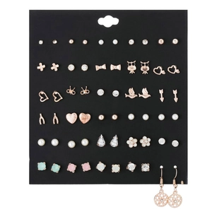 Macro shot of assorted colorful zircon bow and heart stud earrings set on black card