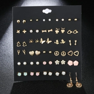 Detailed view of mixed gold stud earring set with zircons and pearls on black card