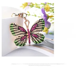 Detailed view of butterfly keychain with pink and green crystals on a gold alloy frame