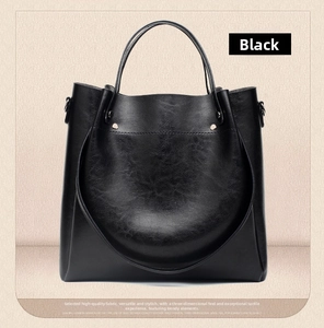 Detailed close-up of premium black oily leather bucket bag with curved stitching accents