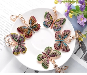 Detailed arrangement of butterfly keychains with colorful rhinestones on a white plate