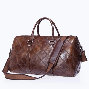 Brown leather travel duffel bag with quilted diamond pattern and adjustable shoulder strap