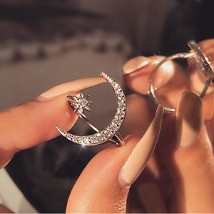 Close-up of silver crescent moon and star ring with clear zircon crystals on model
