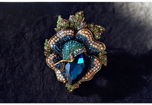 Macro shot of vintage palace style rose brooch with deep blue crystals and rhinestones