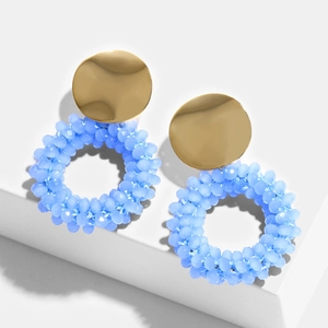 Detailed view of handmade blue beaded hoop earrings with golden metallic studs