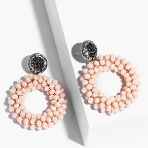 Detail of bohemian round drop earrings with pink beads and shimmering crystal studs