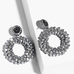 Macro detail of round beaded hoop earrings with silver-grey beads and black studs