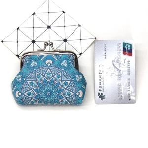 Macro detail of mandala pattern print on vintage canvas coin purse with silver kiss-lock
