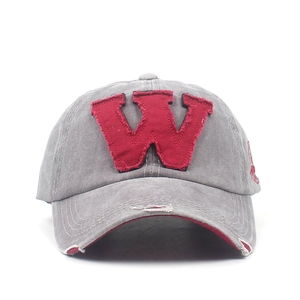 Detailed close-up of vintage washed cotton baseball cap with distressed brim and red W patch