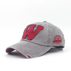 Detail of vintage washed gray baseball cap with red W patch and distressed frayed edges