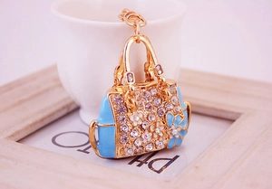 Detailed close-up of blue enamel handbag keychain with gold plating and crystals