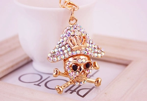Close-up of golden pirate skull keychain with colorful rhinestones and crown detail