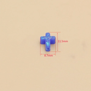 Macro shot of a blue fire opal cross bead measuring 11.5mm by 8.7mm with shiny glitter