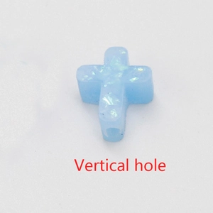 Detailed view of light blue synthetic opal cross bead with vertical hole for DIY jewelry