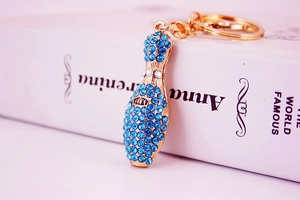 Macro shot of gold bowling pin keychain with blue crystals on a book spine