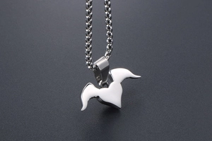 Macro shot of silver stainless steel necklace with abstract wing heart pendant detail