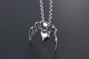 Close-up of gothic silver dragon wings heart pendant on stainless steel chain