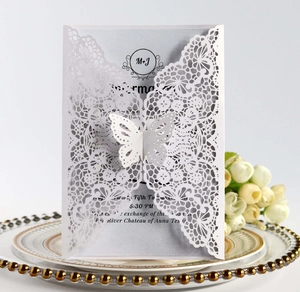 Macro shot of white laser-cut wedding invitation featuring 3D butterfly details