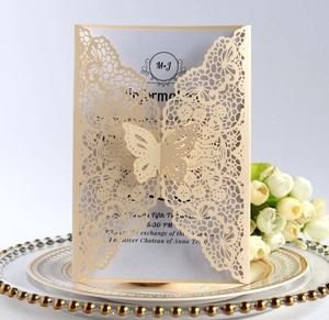 Macro detail of laser-cut butterfly lace invitation with elegant floral backdrop