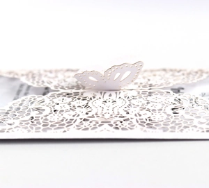 Close-up of elegant laser-cut 3D butterfly wedding invitation with intricate lace patterns