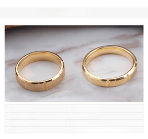 Detail of 18K gold plated couple rings featuring a brushed texture and vertical grooves
