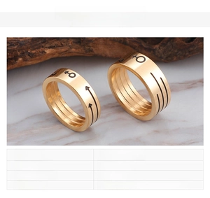 Detailed view of 18K gold plated stainless steel rings with gender symbol engravings