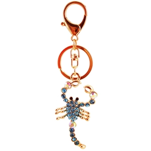 Golden scorpion keychain with blue rhinestones and AB crystal accents on white background