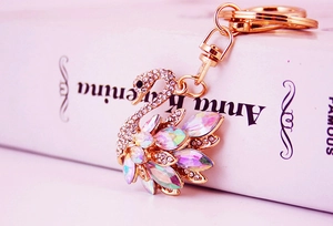 Macro view of white swan keychain with AB crystals on a classic book background