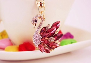 Macro shot of swan keychain with red crystal wings and clear rhinestones on gold metal