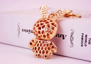 Close-up of rose gold rabbit keychain with rhinestone details on a white book