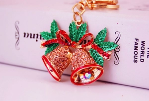 Close-up of a Christmas bell keychain with rhinestones and a festive red bow detail