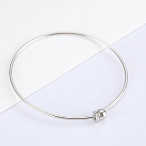 Minimalist polished stainless steel open bangle featuring a metal bead and ring detail