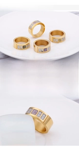 Close-up of golden stainless steel rings set with colorful square gemstones and zircon