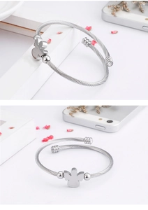 Detail of silver angel zircon cable bracelet with rhinestone accents on a white surface
