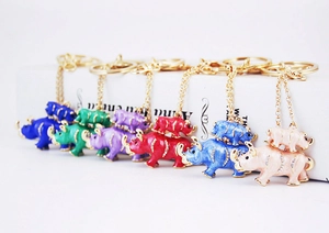 Detail shot of colorful rhinestone rhino keychains in blue, green, and red on white background
