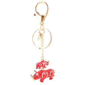 Golden keychain with two red enamel rhinoceros pendants featuring sparkling crystal accents