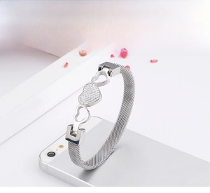 Detail of silver mesh bracelet with heart zircon center on sleek white background