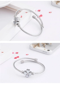 Macro detail of silver twisted cable bracelet featuring shell clover and diamond accents