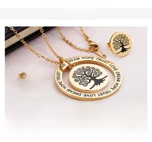 Macro detail of Tree of Life jewelry set with inspirational engraving on 18K gold plating