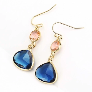 Macro detail of teardrop earrings with pink and blue faceted crystals in gold metal