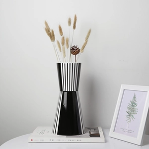 Detailaufnahme einer modernen schwarz-weiß gestreiften Keramikvase auf einem Magazin