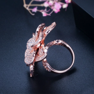 Detailed view of rose gold flower ring encrusted with AAA cubic zirconia on black background