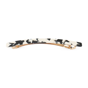 Detail of elegant black and white marble acetate hair clip with golden metal spring base