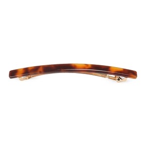 Detail view of acetate tortoise shell hair clip with gold metal spring fastener