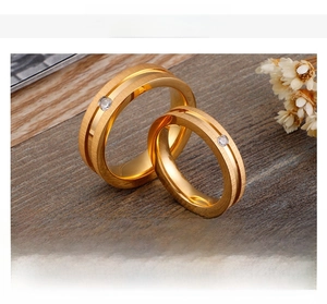 Close-up of gold-plated frosted rings with centered cubic zirconia and matte texture