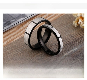 Detailed close-up of stainless steel black and silver rings with brushed matte finish