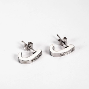 Macro shot of silver J-letter earrings with shimmering pavé cubic zirconia inlay