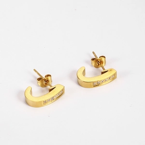 Detail of 18K gold plated J-shaped hook earrings with sparkling cubic zirconia inlay