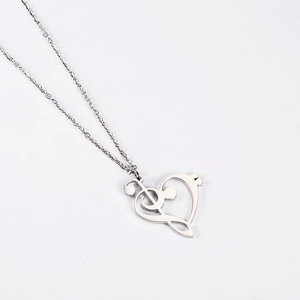 Macro shot of silver heart and music note pendant with polished stainless steel finish