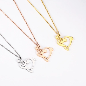 Detailed close-up of musical note heart pendants in gold, rose gold and silver finishes